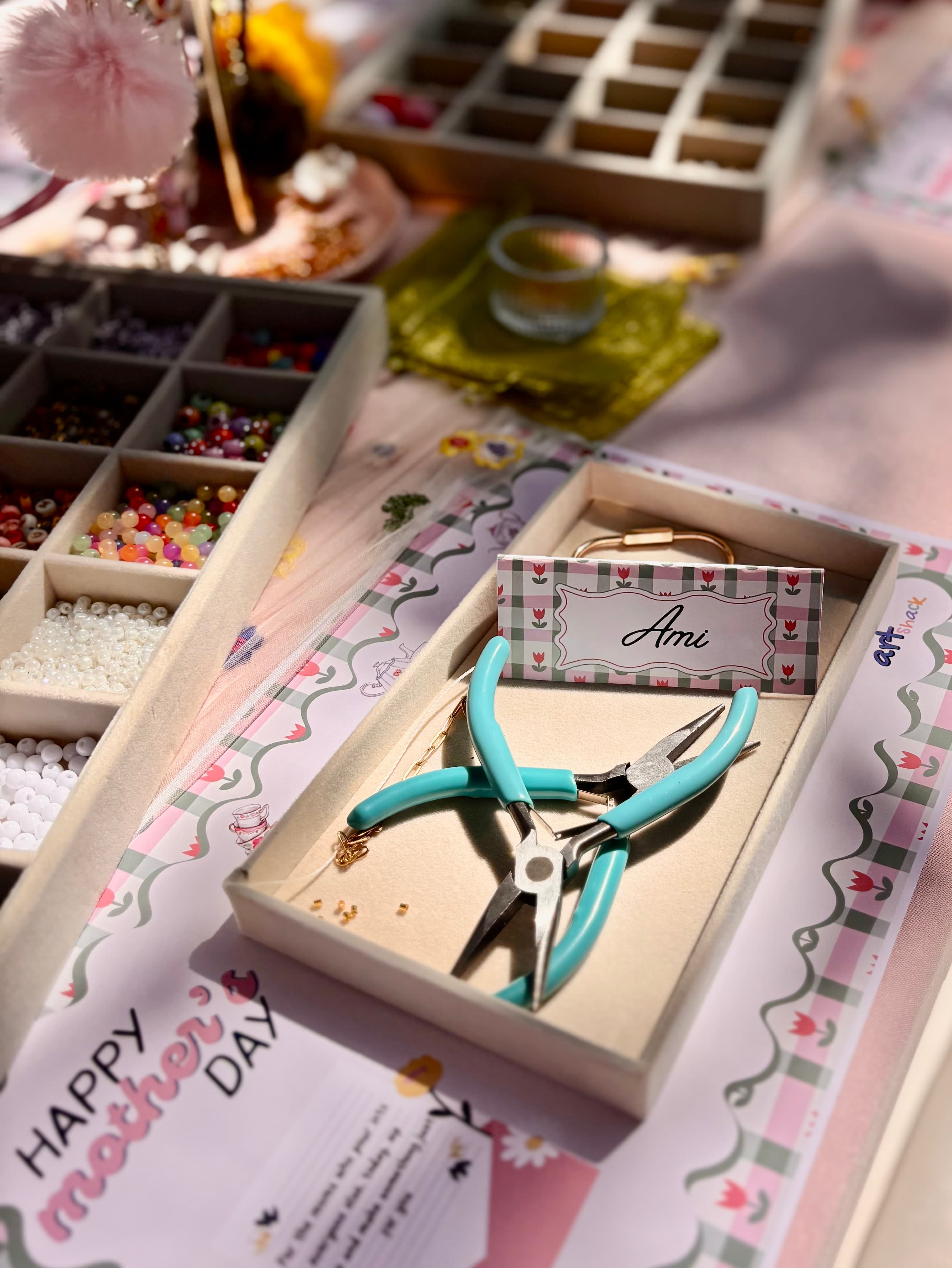 Personalized place setting — name card, teal pliers, pearl and bead trays